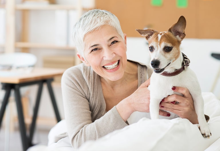 Lächelnde Frau mit Hund im Arm